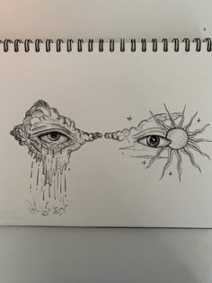 an open notebook with two drawings on it and one has the eye looking at each other