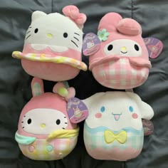 three hello kitty stuffed toys sitting next to each other