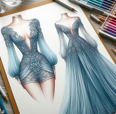 a drawing of two dresses on paper next to colored pencils