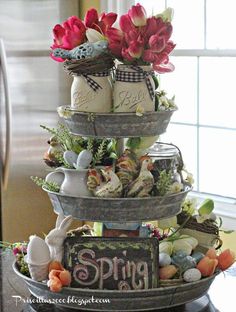 three tiered trays with eggs and flowers in them are stacked on top of each other