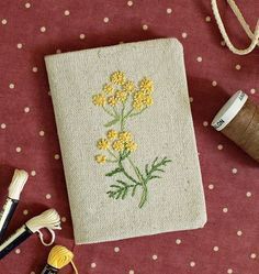 some sewing supplies are laying out on a polka dot tablecloth with a needle and thread