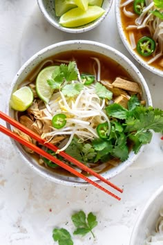 three bowls of soup with chopsticks and garnished with cilantro