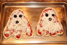 two pizzas shaped like ghostes with cheese on them sitting in a baking pan