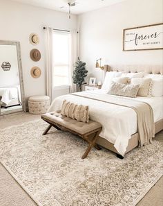 a bedroom with a bed, mirror and bench in the middle of the room on top of a rug