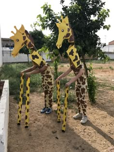 three children in giraffe costumes standing next to each other