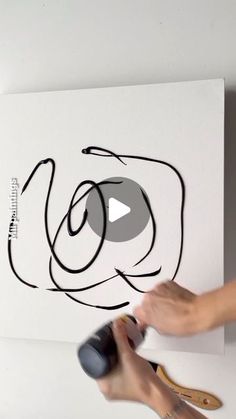 someone is using a mouse to paint a painting on the wall with black and white lines