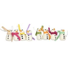 four snowmen with hats and scarfs are hanging from the strings on a white background