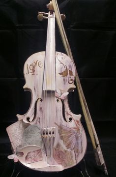 an old violin with writing on it and a stick in its back pocket, sitting against a black background