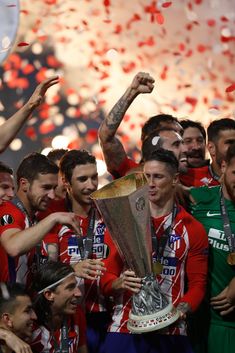 the soccer players are celebrating with their trophy