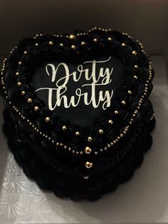 a heart shaped cake with the words dirty thirty written on it