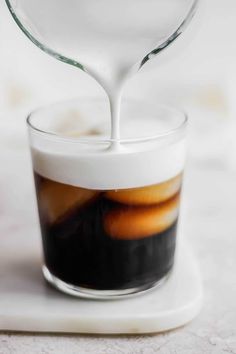 coffee being poured into a glass with liquid