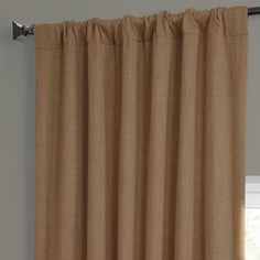 a tan curtain hanging on the side of a window