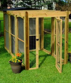 a chicken coop in the grass with potted plants