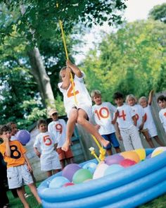 a group of children standing in front of an inflatable pool with numbers on it