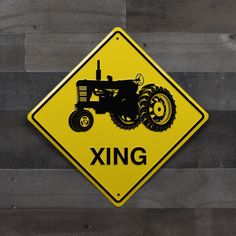 a yellow and black sign that says xing on the side of a wooden wall