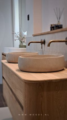 two sinks in a bathroom with wooden counter tops