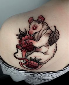 a woman's shoulder with a rat and raspberry tattoo design on it