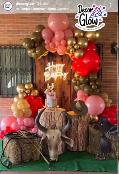 a decorated table with balloons and a cow's head in front of the door