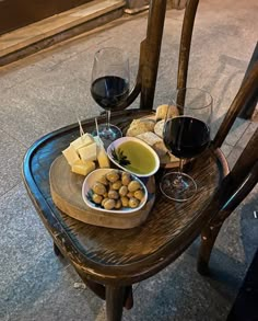 a wooden table topped with wine glasses and food