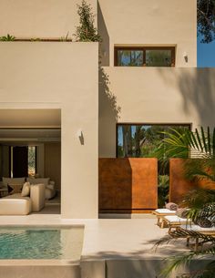 a house with a pool in front of it and lots of greenery on the outside