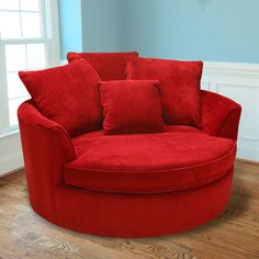 a red round chair with four pillows on it