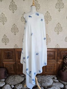 "Neelab" is a refined white shawl, delicately adorned with hand-embroidered sozni motifs in a striking blue. Each floral design is meticulously crafted by skilled Kashmiri artisans, showcasing the precision and dedication involved in traditional needlework. The scattered motifs create a balanced yet captivating pattern, making this piece an ideal blend of simplicity and elegance. A perfect choice for those who value authentic, hand-crafted artistry. Sozni Embroidery, Embroidery Shawl, Embroidered Rug, White Shawl, Wedding Shawls, Scarf Jacket, Stylish Scarves, Silk Carpet, Wool Shawl