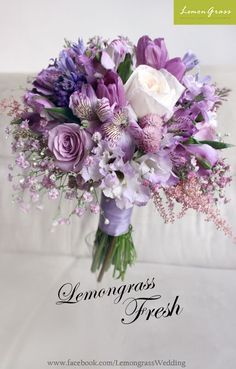 a bouquet of purple and white flowers on a couch