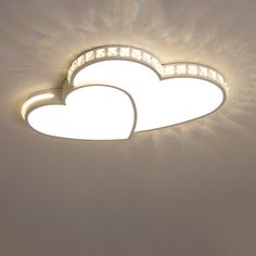 two heart shaped lights on the ceiling in a room with white walls and flooring