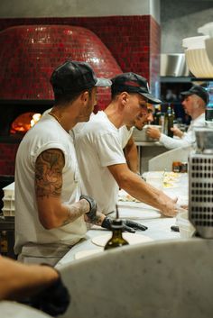 three men working in a kitchen preparing food