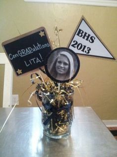 a glass vase filled with confetti and gold sprinkles on top of a metal table