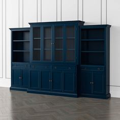 a large blue bookcase with two doors and three drawers in the middle, against a white wall