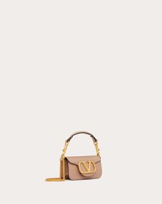 Valentino Garavani Locò micro bag in calfskin leather with chain and VLogo Signature metallic element. Equipped with both a detachable sliding chain strap and a detachable handle, this accessory can be worn as a crossbody/shoulder bag or carried as a handbag. - Antique-brass finish hardware - Magnetic closure - Removable leather handle - Shoulder strap with removable sliding chain - Nappa leather lining. Interior: one card slot Shoulder strap drop length: 55 cm / 21.6 in. - Handle drop length: 7 Valentino Nude Bag, Micro Bag, Women Rising, Valentino Bags, Nappa Leather, Brass Finish, Magnetic Closure, Leather Handle, Crossbody Shoulder Bag