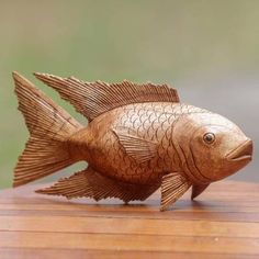 a wooden fish sitting on top of a wooden table