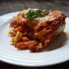 a white plate topped with lasagna covered in sauce