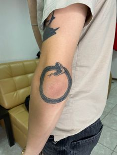 a man with a snake tattoo on his arm