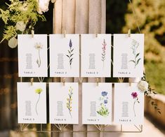 wedding seating cards with flowers hanging from them