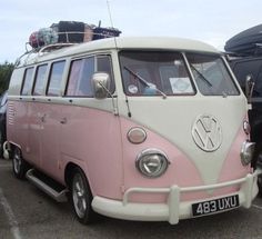 an old pink and white van parked in a parking lot next to other cars with the word style written on it