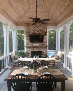 an outdoor living area with couches, table and ceiling fan