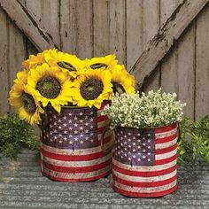 two tin cans with sunflowers and baby's breath in them