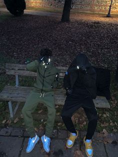 two people sitting on a bench in the park at night with their faces illuminated by flashlights