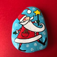 a painted rock with a santa clause on it