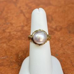 New, but old pieces, never worn, recently acquired from a premier jeweler located in Minneapolis, MN for many years- A rare opportunity! 14KT yellow gold genuine, bezel-set, Mabe pearl ring with Etruscan/ filigree design. Size 6.25 Sizable by us for a fee or your local jeweler Weight: 7.90 grams Band width: 4mm 11mm pearl Stamped 14k Classic White Gold Cabochon Jewelry, Classic Oval Cabochon Collectible Jewelry, Yellow Gold Cabochon Pearl Ring For Gift, Yellow Gold Cabochon Pearl Ring As Gift, Cabochon Pearl Ring In Yellow Gold For Gift, Heirloom Style Yellow Gold Cabochon Jewelry, Classic Wedding Jewelry With Cabochon, Formal Yellow Gold Cabochon Jewelry, Heirloom High Luster Oval Pearl Ring