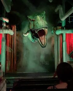 a large dinosaur head hanging from the ceiling