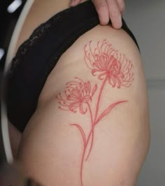 a woman's thigh with a flower tattoo on it