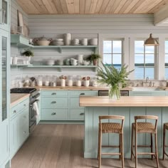 a kitchen filled with lots of counter space and wooden flooring next to an ocean view