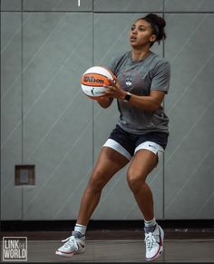 a woman holding a basketball in her right hand