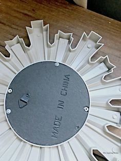 a metal clock with the words made in china on it's face and bottom