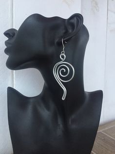 The earrings are made of Aluminum with the wire technique.Modern earrings.  Aluminum Silver Earrings.  Modern Designe.Silver Spiral Large Earrings. Handmade. This spiral shape earrings are a statement piece, the perfect accessory to complete a stunning outfit look. Ideal for a casual fashion style. Materials:  - Aluminum wire (2.0 mm). The material I use to wrap aluminum wire, that means, is not heavy at all. Aluminum is lightweight and will never tarnish. I give it a slightly hammered texture and wrap the glass stone with it. SIZE: This big and chunky silver wire earrings are made of one piece of pure aluminum wire. After twisting and wrapping they are hammered. DIMENSIONS: Length: 7 cm = 2,8 in Width: 3.5 cm = 1.8 in COLOR:  Silver, aluminum  wire Try to keep it away from water. Shipping Swirl-shaped Earrings With Ear Wire, Spiral Earrings With Ear Wire As Gift, Spiral Earrings With Ear Wire For Gifts, Handmade Swirl Earrings For Gifts, Handmade Swirl Earrings As Gift, Spiral Wire Earrings With Ear Wire, Spiral Metal Earrings With Ear Wire, Metal Spiral Earrings With Ear Wire, Spiral Silver-plated Wire Earrings