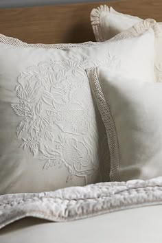 two white pillows sitting on top of a bed