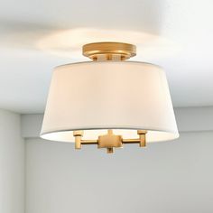 a light fixture hanging from the ceiling in a room with white walls and flooring